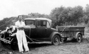 Ernie Woods with camp trailer and car in 1936.